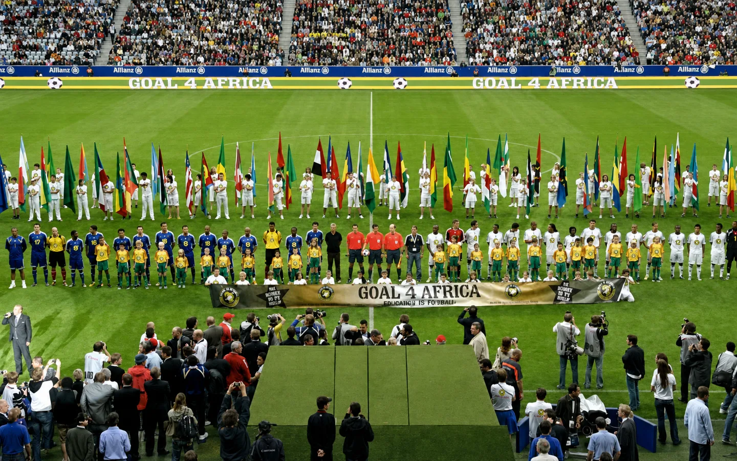 Panoramic Goal4Africa ceremony with footballers, children and international flags at the Allianz Arena.